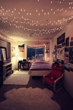 a bedroom with lights strung from the ceiling and pictures on the wall above the bed