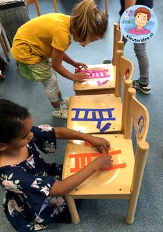 two children are playing with letters on chairs