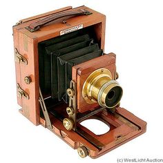 an old fashioned wooden camera with metal parts