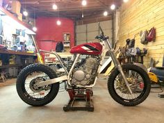 a red motorcycle parked inside of a garage