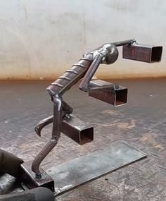 a metal sculpture sitting on top of a wooden table