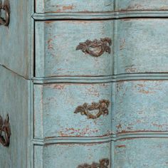 an old blue dresser with ornate handles and knobs