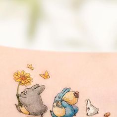 an arm with some tattoos on it that have animals and flowers painted on the side