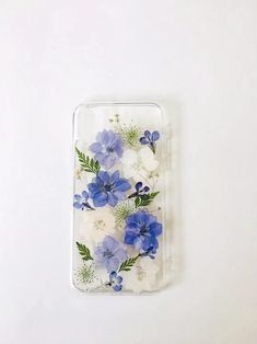 blue and white flowers are arranged on the back of a clear case for an iphone