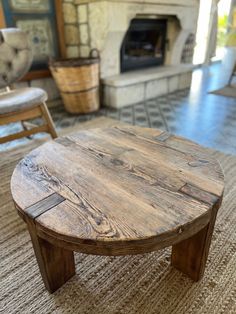 a wooden table sitting on top of a carpeted floor next to a fire place