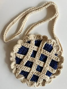 a crocheted bag with blue and white squares hanging from it's side