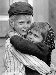 two children hugging each other on the street