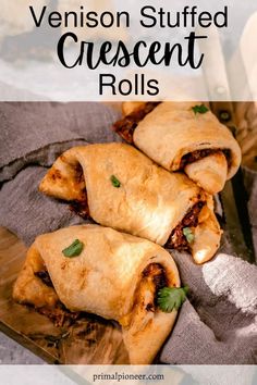 three venison stuffed crescent rolls on a wooden cutting board with text overlay