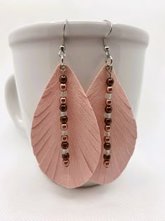 a pair of pink leather earrings with beads