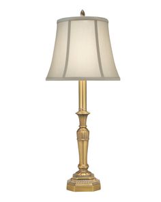 a gold lamp with a white shade on it