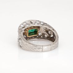 This is part of Chairish’s Fine Jewelry assortment.  Stylish and finely detailed emerald & diamond ring crafted in 900 platinum.  Center set emerald measures 5.5mm x 4mm. Diamonds total an estimated 0.75 carats (estimated at H-I color and VS2-SI2 clarity). Note: few chips to the emerald (visible under a 10x loupe).  With an emerald to the center the low dome band is set with sparkling diamonds. Etched palmette details add depth and texture, finished with fine milegrain. The ring is great worn al Hallmarked Oval Emerald Ring In Platinum, Oval Hallmarked Emerald Ring In Platinum, Green Emerald Ring With Diamond Accents In Platinum, Platinum Emerald Ring With Diamond Accents, Heirloom Hallmarked Emerald Ring In Platinum, White Gold Emerald Ring With Prong Setting In Platinum, Platinum White Gold Emerald Ring With Prong Setting, Heirloom Platinum Hallmarked Emerald Ring, Fine Jewelry Emerald Ring With Platinum