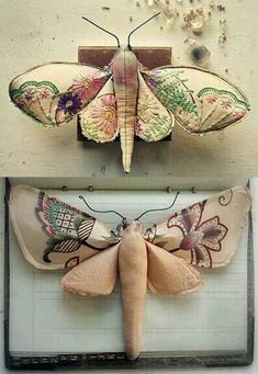 two butterflies are hanging on the wall and one is made out of fabric with beads