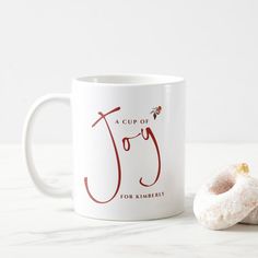 a cup of joy for remembrance coffee mug next to a donut