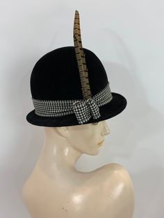 "\"It's not the shape of a woman's face that really decides, but the attitude of the hat\" Frank Olive And this hat has some attitude! Black velvet bowler style with a wool black and white houndstooth ribbon band, that end at the right side with a two loops and a long pheasant feather. inside is a smooth wool felt with a pink grosgrain band. Label: Frank Olive Bloomingdales New York Stamped: Cotillion Imported Made in France 20\" circumference around inner grosgrain band 6\" high with an 1.5\" b Vintage Top Hat With Short Brim For Fall, Vintage Short Brim Top Hat For Fall, Vintage Cloche Hat With Curved Brim For Fall, Vintage Cloche Hat For Fall, Vintage Fedora Top Hat For Fall, Vintage Wide Brim Mini Hat For Fall, Vintage Top Hat For Fall Party, Vintage Formal Hat For Fall, Vintage Hat Bands For Fall