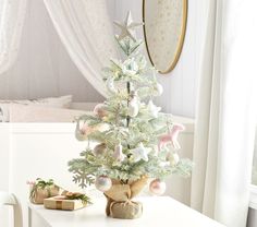 a small white christmas tree sitting on top of a table