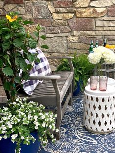 two wooden chairs sitting on top of a blue and white rug next to a tree