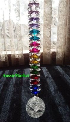 a multicolored glass beaded vase sitting in front of a window