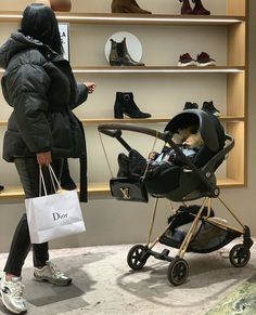 a woman is looking at her baby in a stroller while she shops for shoes