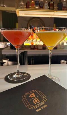 two martinis sitting next to each other on a bar