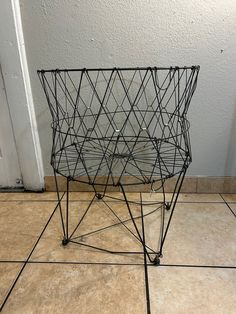 a wire basket sitting on top of a tiled floor