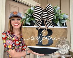 a woman is holding up a welcome sign