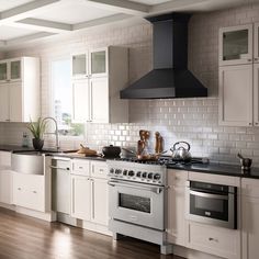 a kitchen with white cabinets and stainless steel appliances, including a range hood over the stove