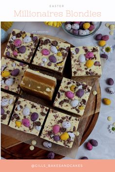 a wooden tray topped with pieces of cake next to easter eggs and chocolate candies