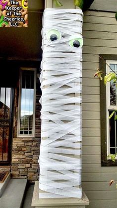 a tall tower made out of toilet paper with googly eyes on it's side