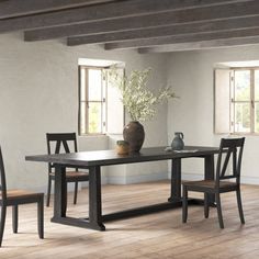 a dining room table with chairs and a vase