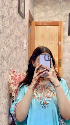 a woman taking a selfie in front of a mirror with her hands on her face