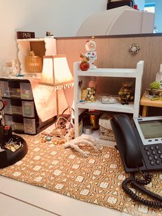 an old phone is sitting on the floor next to a shelf with other items in it