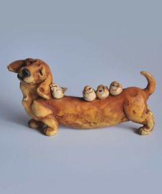 a ceramic dog figurine with three little birds on its back