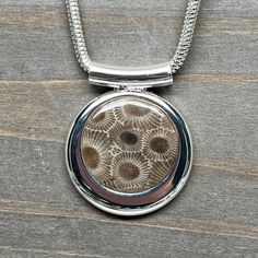 Very nice Petoskey Stone with rich color and high contrast. This beautiful pendant comes on a 16", 18'',  20"  or 24'' chain. Silver plated "Pewter" (zinc-based alloy) The stone measures 1 inch in diameter. The pendant measures 1.125 inches wide by 1 inch tall. Petoskey stone is a fossilized coral, the state stone of Michigan and is commonly found along the shores of Lake Michigan and Lake Huron in the United States. It was formed by the fossilization of ancient coral, hexagonaria. These corals Sterling Silver Brown Round Pendant Necklace, Brown Sterling Silver Round Pendant Necklace, Unique Etched Round Pendant Necklace, Etched Round Necklaces For Jewelry Making, Brown Round Necklace With Lobster Clasp, Fossilized Coral, Petoskey Stone, Lake Huron, Chain Silver