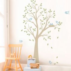 a child's room with a tree and birds on the wall