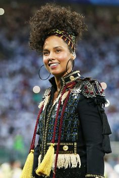 a woman with an afro is standing in front of a crowd at a sporting event