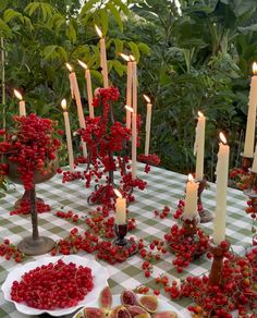 a table topped with plates filled with fruit and candles