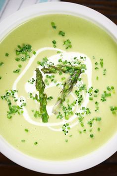 a bowl of soup with asparagus and cream in it