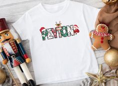 Adorable Personalized Christmas Name Shirt, spreading joy and cheer all season long. Crafted with love and attention to detail, this charming shirt features your child's custom name elegantly intertwined with Christmas-themed letters, accompanied by a playful Santa and his trusty reindeer peeking from within. Available in three delightful colors - white, light blue, or light pink - a perfect addition to your little one's festive wardrobe. Key Features: ✨Premium Quality Fabric: Made from soft, breathable material for ultimate comfort.  ✨Custom Name Inclusion: Make it uniquely theirs with your child's name in charming Christmas letters.  ✨Festive Design: Heartwarming Santa and reindeer peek out from the letters, adding enchantment.  ✨Available Colors: Choose from classic white, gentle light Alphabet Boy, Letters Christmas, Meet Santa, Christmas Names, Christmas Alphabet, Bubble Letters, Christmas Lettering, Santa And Reindeer, Custom Christmas