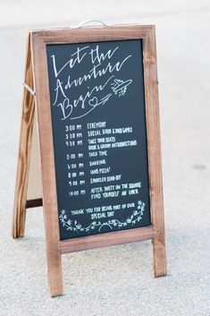 a chalkboard sign sitting on the side of a road