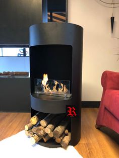 a fire place in the middle of a living room with wood logs stacked around it