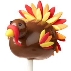 a chocolate turkey lollipop sitting on top of a white stick in front of an orange polka dot background