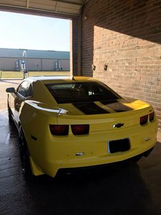 a yellow sports car parked in a garage