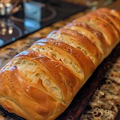 a long loaf of bread sitting on top of a counter next to a burner