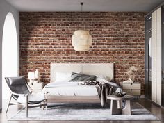 a bedroom with a brick wall and white bed in the center, two chairs on either side