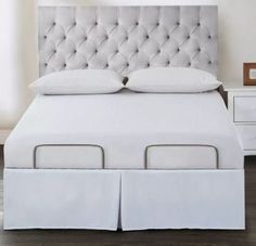 a white bed with two pillows on top of it and drawers underneath the headboard