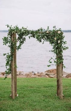 an image of a wedding arch made out of branches and flowers on the grass with text reading romantic lakeside navy and bush wedding article from every last