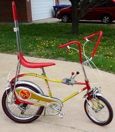 a red and yellow bicycle parked on the sidewalk