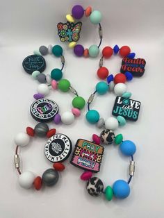 a bunch of different colored beads on a white surface with the words love jesus written on them