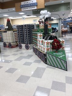 the christmas decorations are on display in the store's department mall lobby, which is decorated with holiday themed boxes and ribbons