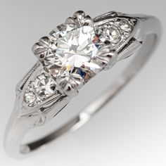 an antique style diamond ring with three stone accents